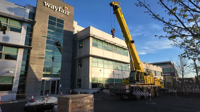 commercial solar panels photo of crane lifting panels onto roof